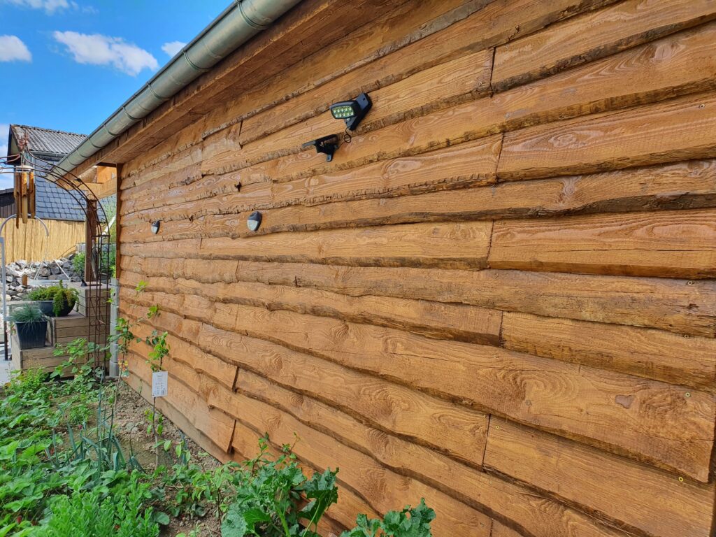 Schwartenbretter als Verblendung einer Fassade vom Gartenhaus