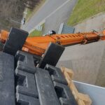 Cramer Manitou Teleskoplader beim Bauzaunfüsse auf Flachdach laden