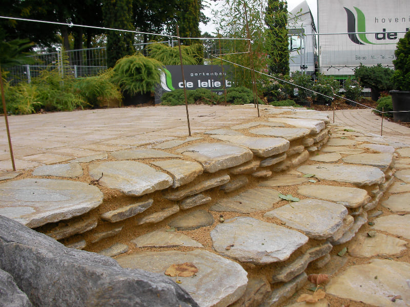 Bild Foto Naturstein Gartentreppe Nach der Fertigstellung unseres Hauses mit einer schönen Fassade steht nun die Gestaltung des Außenbereichs an. Mit der Hilfe des erfahrenen Teams von Gartenbau Geretsried planen wir sowohl den hinteren Garten als auch den Vorgarten. Unser Ziel ist es, eine einzigartige Mischung aus naturnahem Lebensraum und luxuriöser Funktionalität zu schaffen.